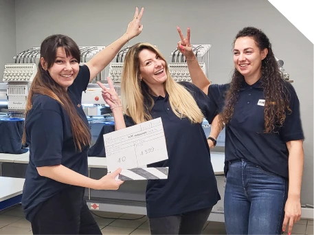 Équipe HM Marquage devant les machines de broderie de l'atelier