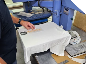 Pressage à chaud d'un logo sur t-shirt blanc à l'atelier HM Marquage